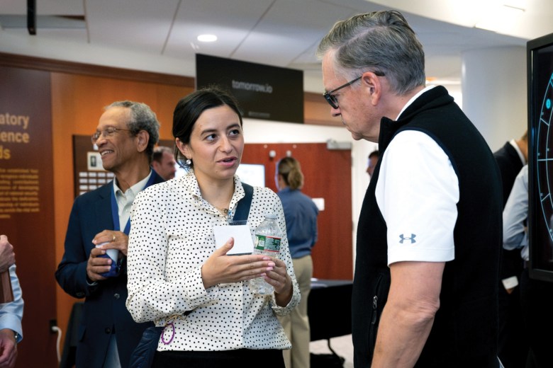 MIT AeroAstro Department members Evana Gizzi (left) and Olivier de Weck (right) chat in front of the department’s exhibit on a game called GEOPatrol that simulates non-cooperative interactions in space between two space actors. Credit: Nicole Fandel/MIT Lincoln Laboratory