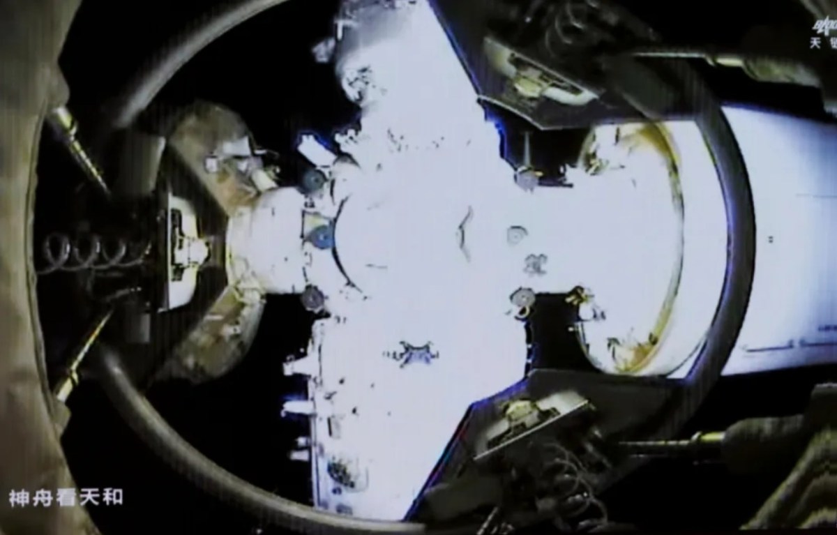 View from Shenzhou-20 spacecraft showing the docking interface with the Tiangong space station on April 24, 2025. The image captures the moment of docking, with structural elements and connection points of both spacecraft visible under bright illumination.